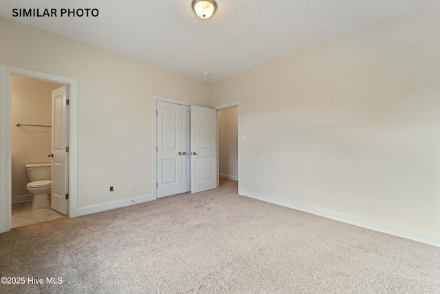 284 Water Wagon Trl, Jacksonville, NC 28546 - unfurnished bedroom with light colored carpet, ensuite bath, a closet, and baseboards
