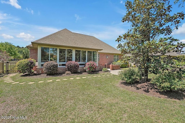 1061 Leesburg Dr, Leland, NC 28451 - back of property with brick siding, a lawn, a shingled roof, and fence