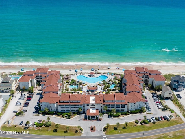 birds eye view of property with a water view and a beach view