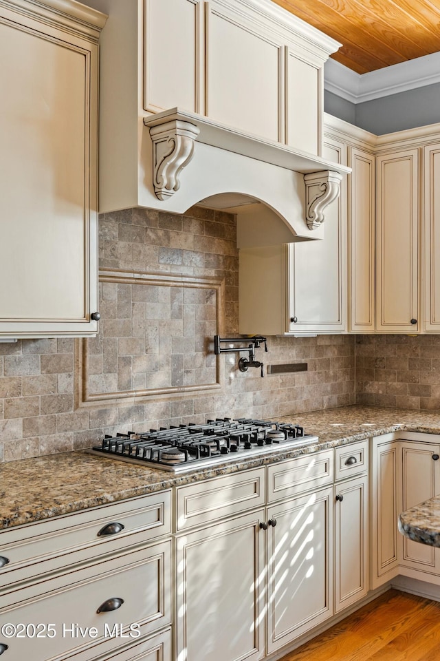 1037 Anchors Bend Way, Wilmington, NC 28411 - kitchen featuring stainless steel gas cooktop, light stone countertops, cream cabinets, and tasteful backsplash