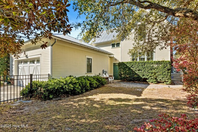 1037 Anchors Bend Way, Wilmington, NC 28411 - view of side of property with an attached garage, fence, and metal roof