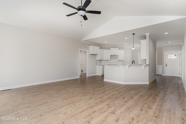 30 Tee Dr, Selma, NC 27576 - unfurnished living room featuring lofted ceiling, visible vents, a ceiling fan, and light wood-style flooring