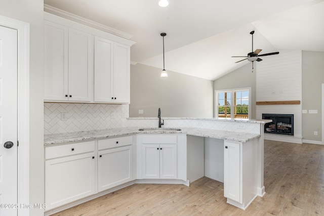 30 Tee Dr, Selma, NC 27576 - kitchen featuring a peninsula, a sink, white cabinetry, decorative backsplash, and ceiling fan