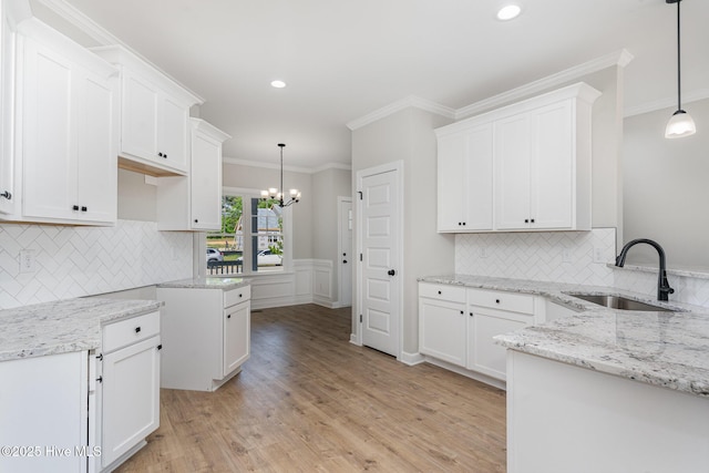 30 Tee Dr, Selma, NC 27576 - kitchen with light stone countertops, a sink, white cabinetry, and ornamental molding