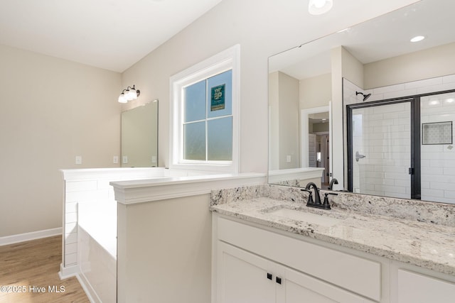 30 Tee Dr, Selma, NC 27576 - full bathroom featuring wood finished floors, vanity, baseboards, a garden tub, and a stall shower
