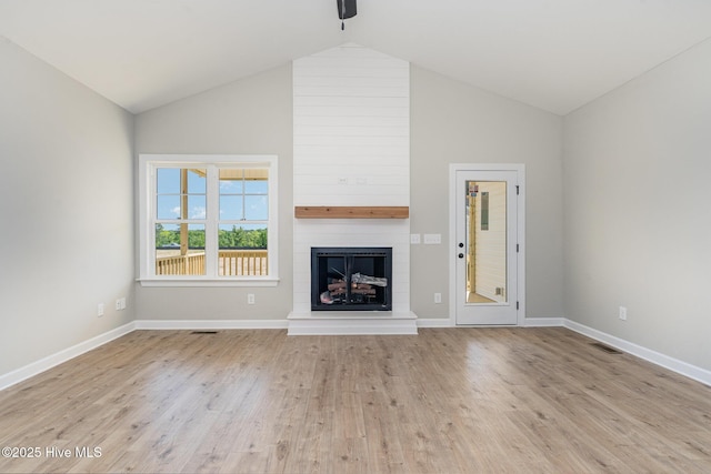 30 Tee Dr, Selma, NC 27576 - unfurnished living room with baseboards, visible vents, high vaulted ceiling, wood finished floors, and a fireplace