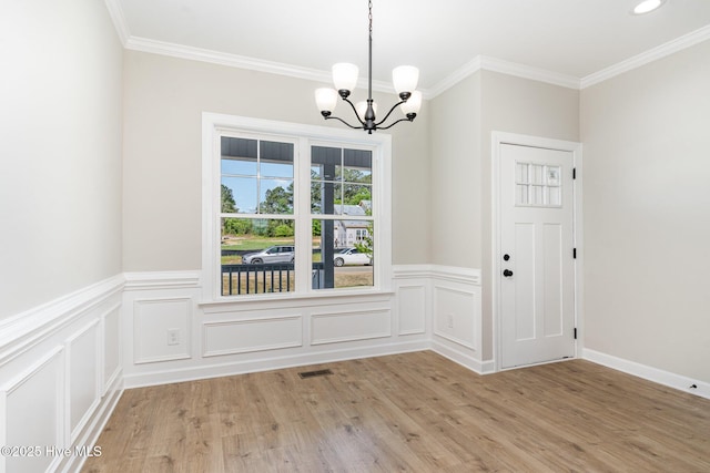 30 Tee Dr, Selma, NC 27576 - unfurnished dining area featuring light wood finished floors, wainscoting, an inviting chandelier, and crown molding