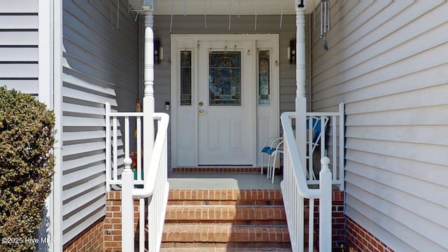 entrance to property with brick siding and covered porch