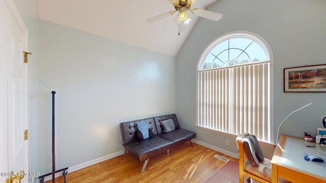 office space featuring a ceiling fan, wood finished floors, visible vents, baseboards, and lofted ceiling