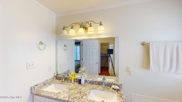 bathroom featuring a sink, ornamental molding, and double vanity