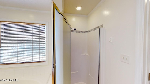 bathroom with a stall shower, crown molding, and a garden tub