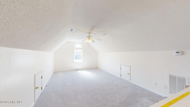 bonus room featuring visible vents, carpet, ceiling fan, lofted ceiling, and a textured ceiling