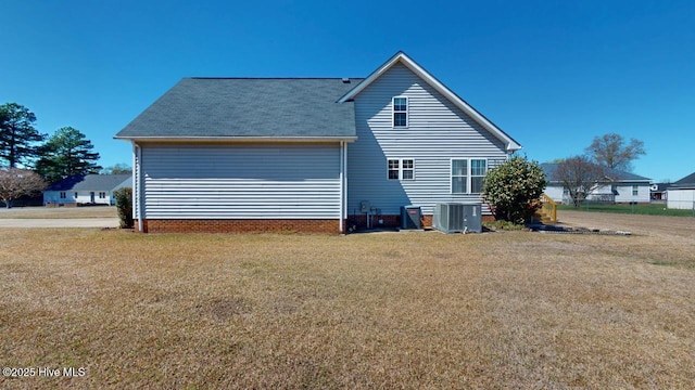 rear view of house with a lawn and central AC