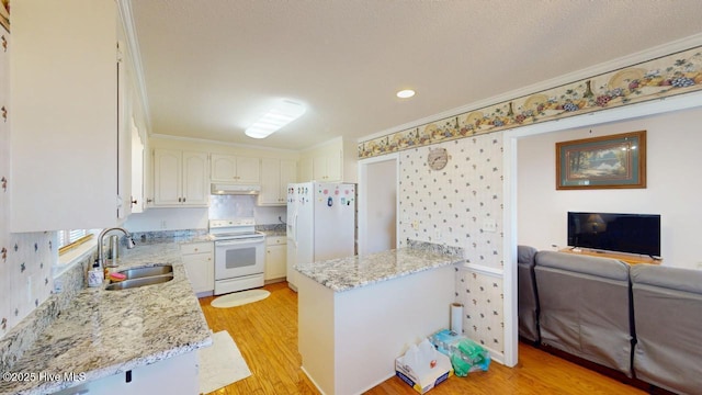 kitchen with light wood-type flooring, a sink, under cabinet range hood, white appliances, and a peninsula