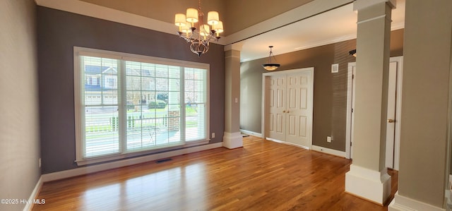 2429 Falls River Ave, Raleigh, NC 27614 - unfurnished dining area featuring plenty of natural light, wood finished floors, a chandelier, and ornamental molding