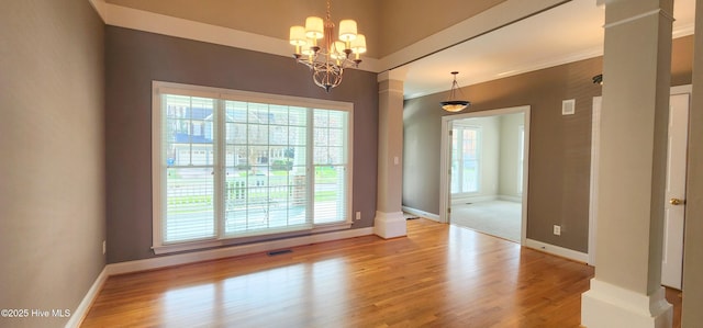 2429 Falls River Ave, Raleigh, NC 27614 - spare room featuring wood finished floors, decorative columns, and a chandelier