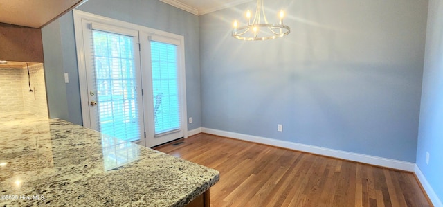 2429 Falls River Ave, Raleigh, NC 27614 - unfurnished dining area featuring wood finished floors, a chandelier, and crown molding
