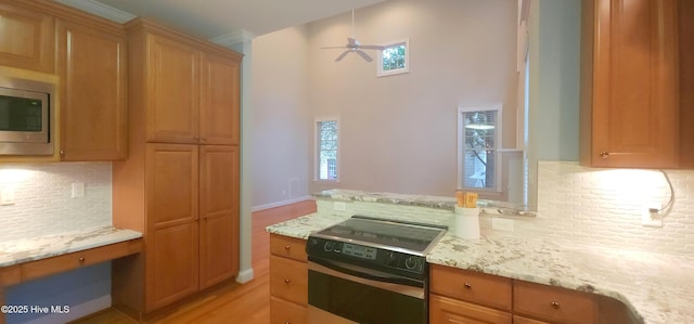 2429 Falls River Ave, Raleigh, NC 27614 - kitchen with electric stove, a ceiling fan, tasteful backsplash, stainless steel microwave, and light stone countertops
