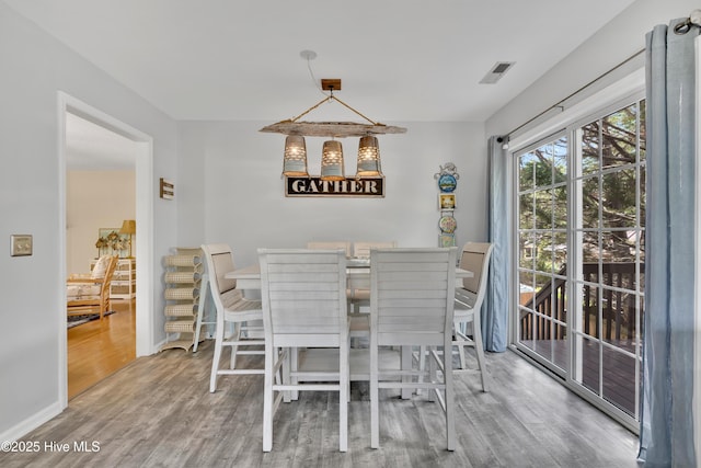 222 NE 36th St, Oak Island, NC 28465 - dining area with wood finished floors, visible vents, and baseboards