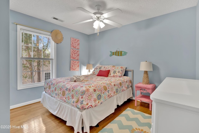 222 NE 36th St, Oak Island, NC 28465 - bedroom with a textured ceiling, visible vents, wood finished floors, and baseboards