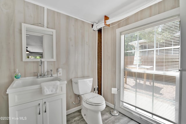 222 NE 36th St, Oak Island, NC 28465 - bathroom featuring toilet, wood finished floors, vanity, and baseboards