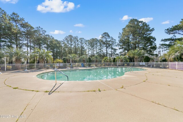659 Meadowbrook Ln NW, Calabash, NC 28467 - community pool featuring fence, a patio area, and view of scattered trees