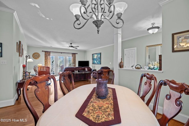 dining area with wood finished floors, baseboards, decorative columns, crown molding, and ceiling fan with notable chandelier