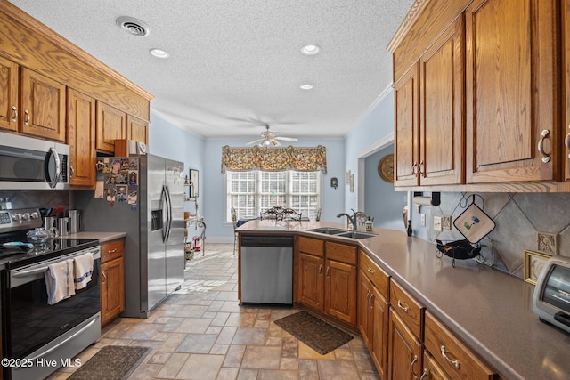 kitchen with brown cabinetry, visible vents, appliances with stainless steel finishes, and a sink