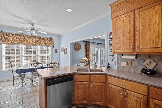 kitchen featuring a sink, a peninsula, crown molding, and stainless steel dishwasher