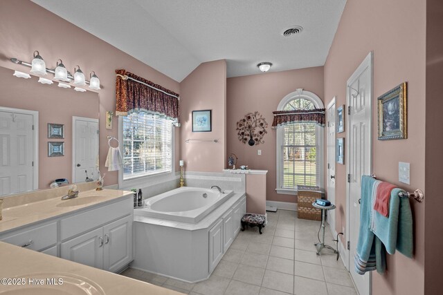 full bathroom featuring tile patterned flooring, visible vents, lofted ceiling, a bath, and vanity
