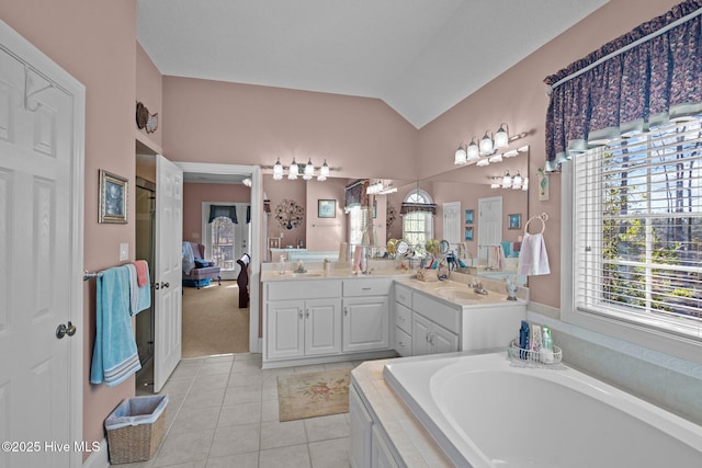 full bath featuring tile patterned floors, a sink, double vanity, lofted ceiling, and a bath