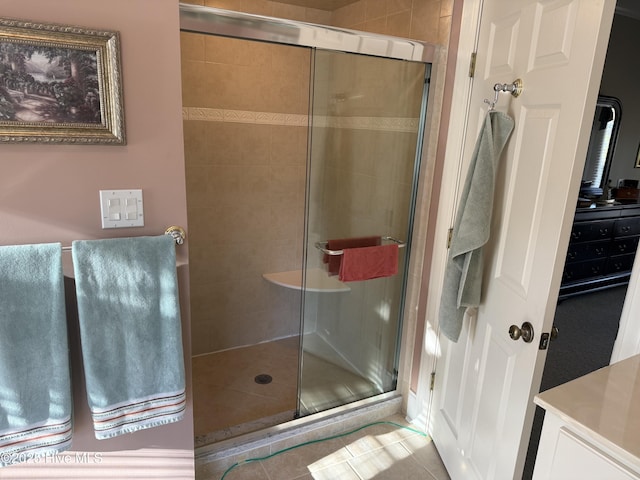 full bath featuring tile patterned flooring and a shower stall