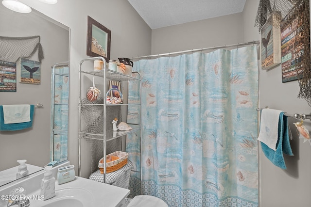full bathroom with a textured ceiling, vanity, and a shower with shower curtain