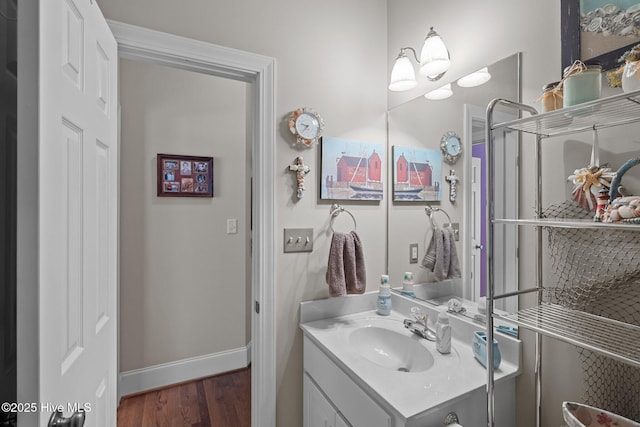 bathroom featuring vanity, baseboards, and wood finished floors