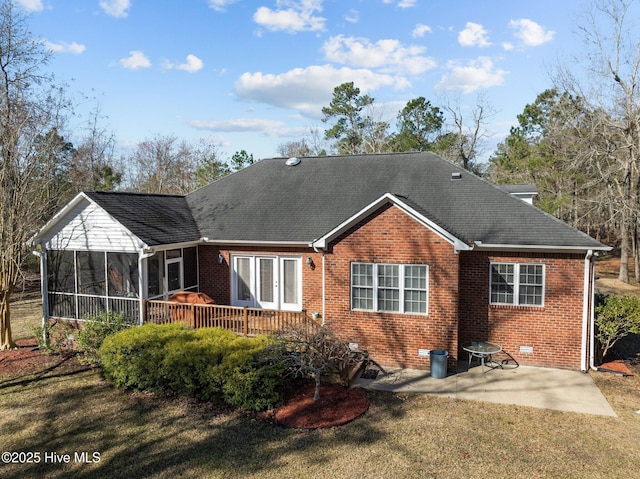 rear view of property featuring a yard, a patio area, brick siding, and a sunroom