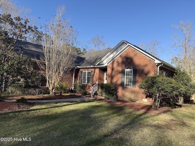 ranch-style house featuring brick siding and a front lawn