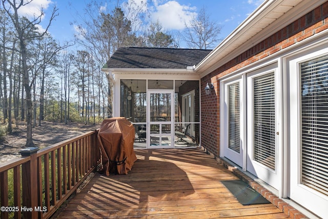wooden terrace featuring grilling area and a sunroom