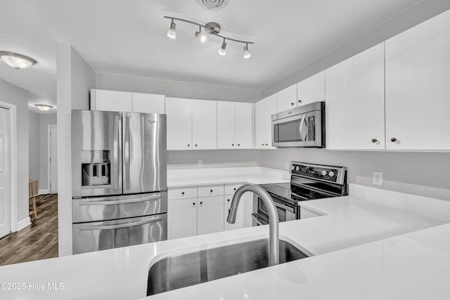 6211 Wrightsville Ave Unit 111, Wilmington, NC 28403 - kitchen featuring stainless steel appliances, light countertops, wood finished floors, and white cabinets