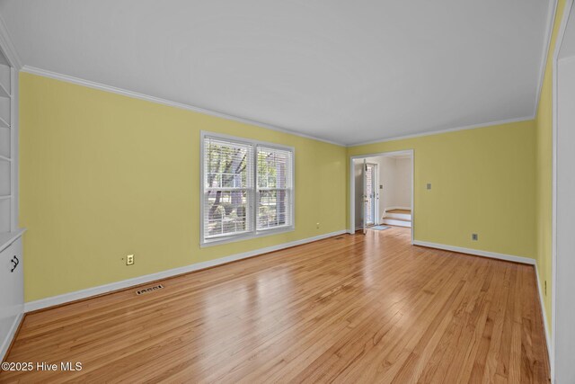 interior space with baseboards, visible vents, ornamental molding, and light wood-style floors