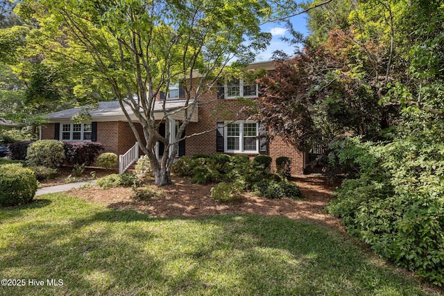 view of front of house featuring brick siding and a front lawn