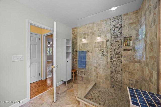 bathroom with baseboards and a tile shower
