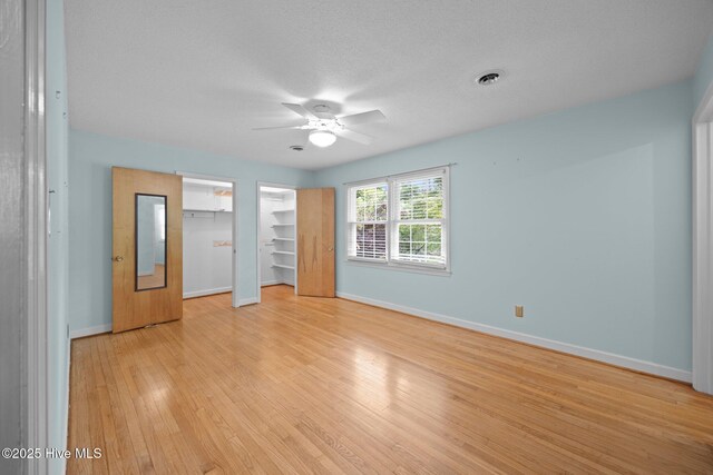 unfurnished bedroom with a ceiling fan, baseboards, and light wood-style flooring