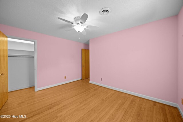 unfurnished bedroom with visible vents, a ceiling fan, light wood finished floors, and baseboards