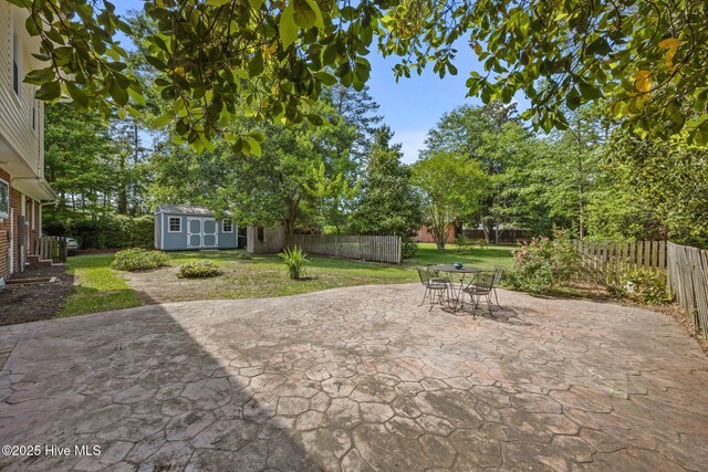 view of patio / terrace featuring a storage shed, outdoor dining space, an outdoor structure, and a fenced backyard