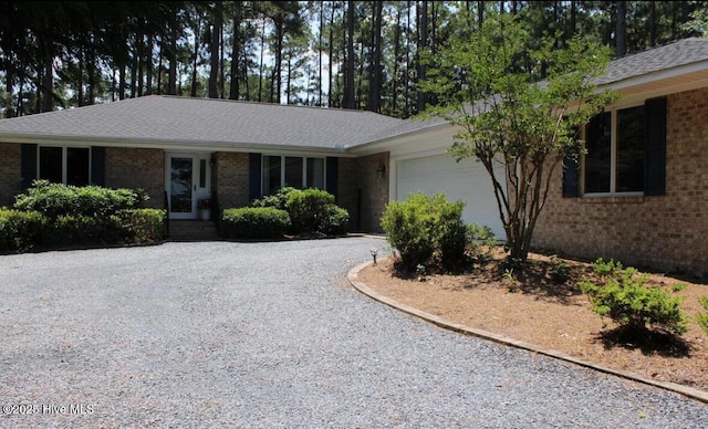 ranch-style house with brick siding, a garage, and driveway