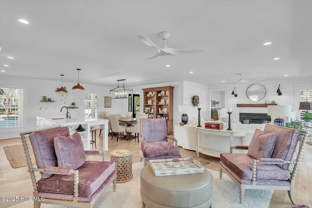 7522 Dunbar Rd, Wilmington, NC 28411 - living area featuring ceiling fan, light wood finished floors, recessed lighting, a glass covered fireplace, and a chandelier