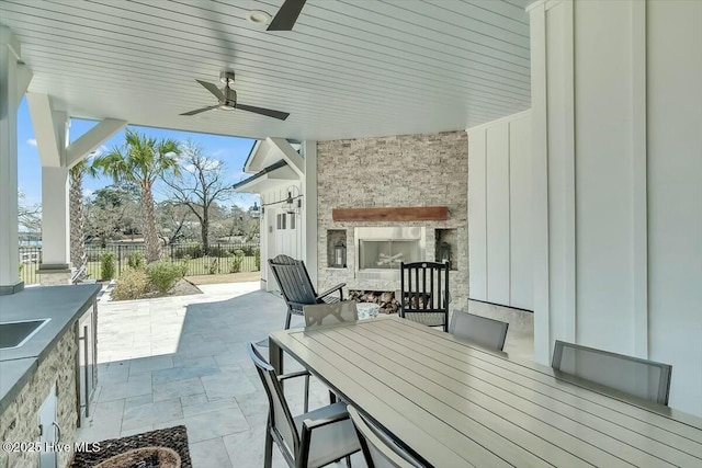 7522 Dunbar Rd, Wilmington, NC 28411 - view of patio / terrace featuring an outdoor fireplace, an outdoor kitchen, a ceiling fan, and outdoor dining area