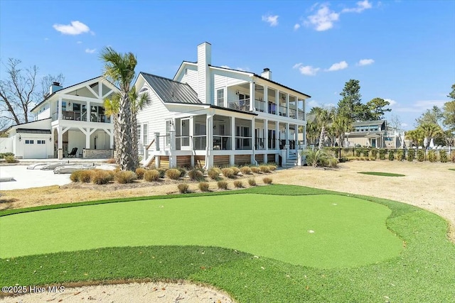 7522 Dunbar Rd, Wilmington, NC 28411 - back of property featuring a balcony, a putting green, and a chimney