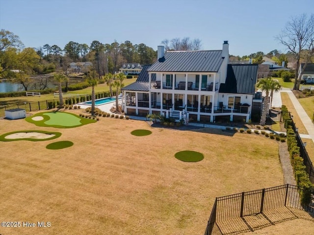 7522 Dunbar Rd, Wilmington, NC 28411 - back of property featuring a chimney, an area to practice putting, a balcony, and a metal roof