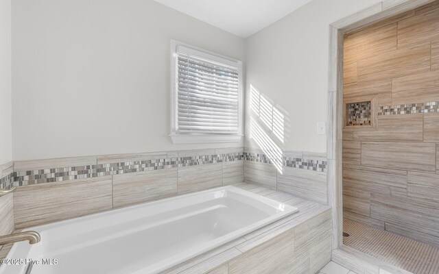 full bath featuring tiled shower and a garden tub